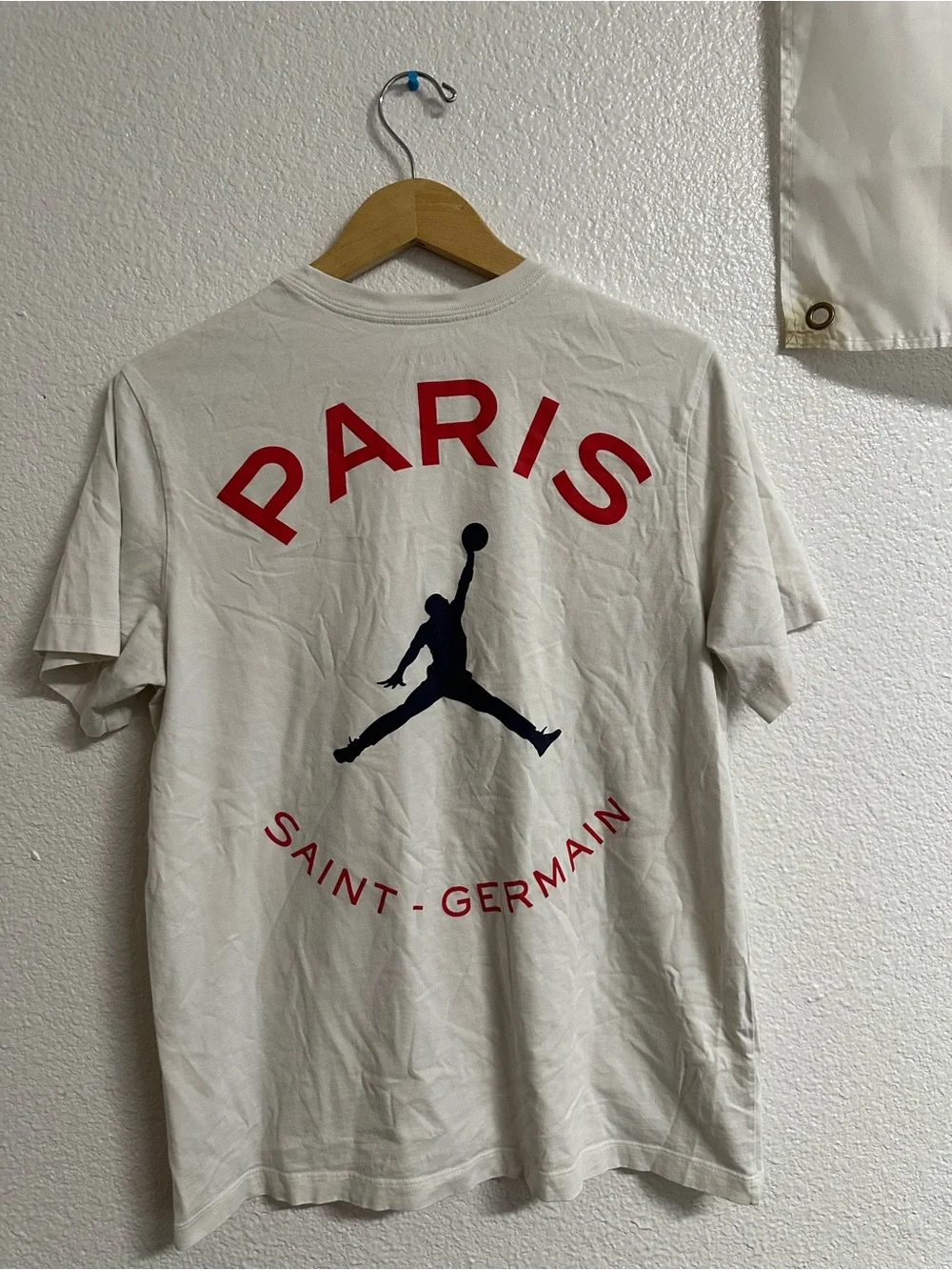 Jordan Paris Saint-Germain Cream Graphic Tee with Red and Black Logo